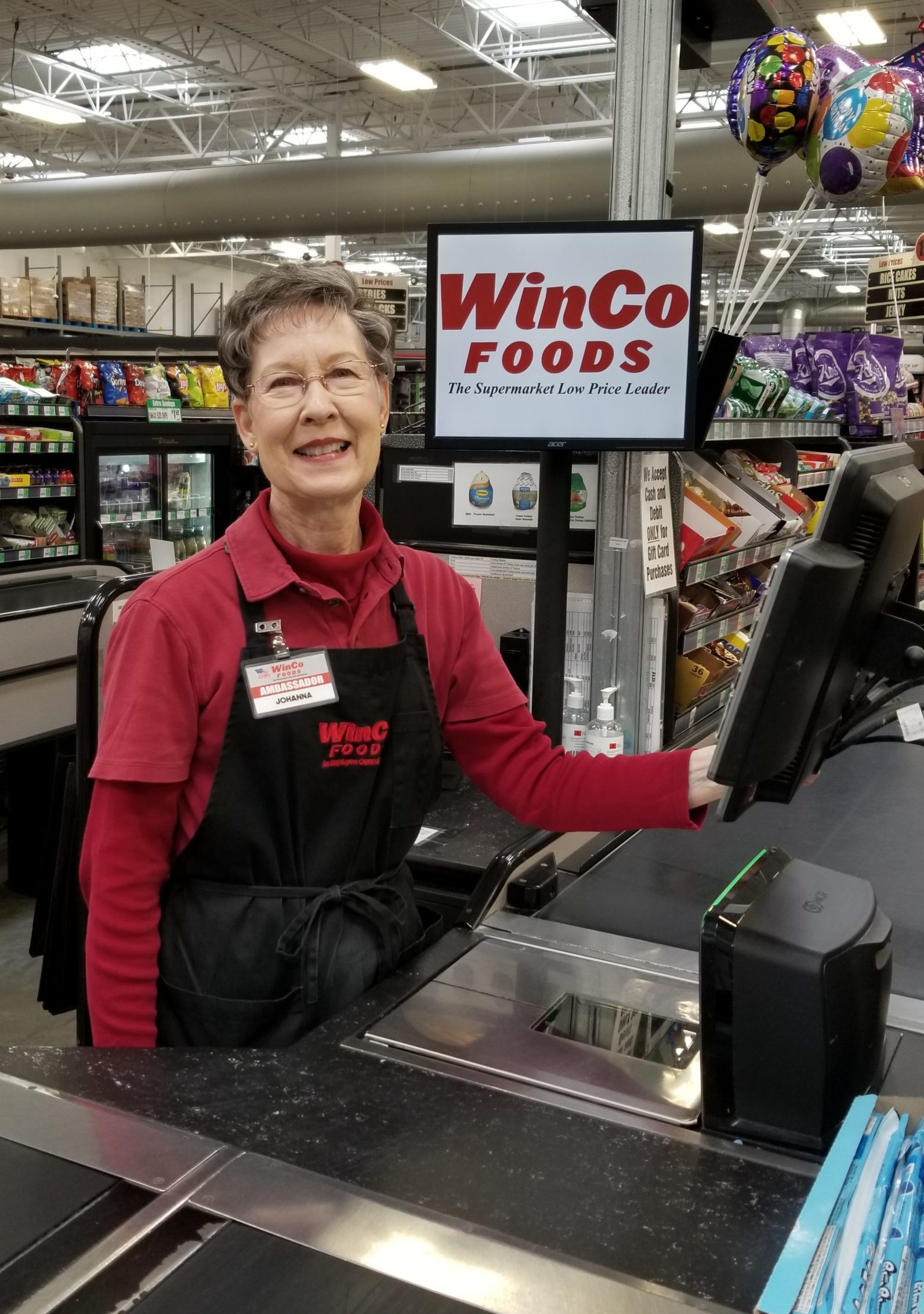 Smiling WinCo employee at the register